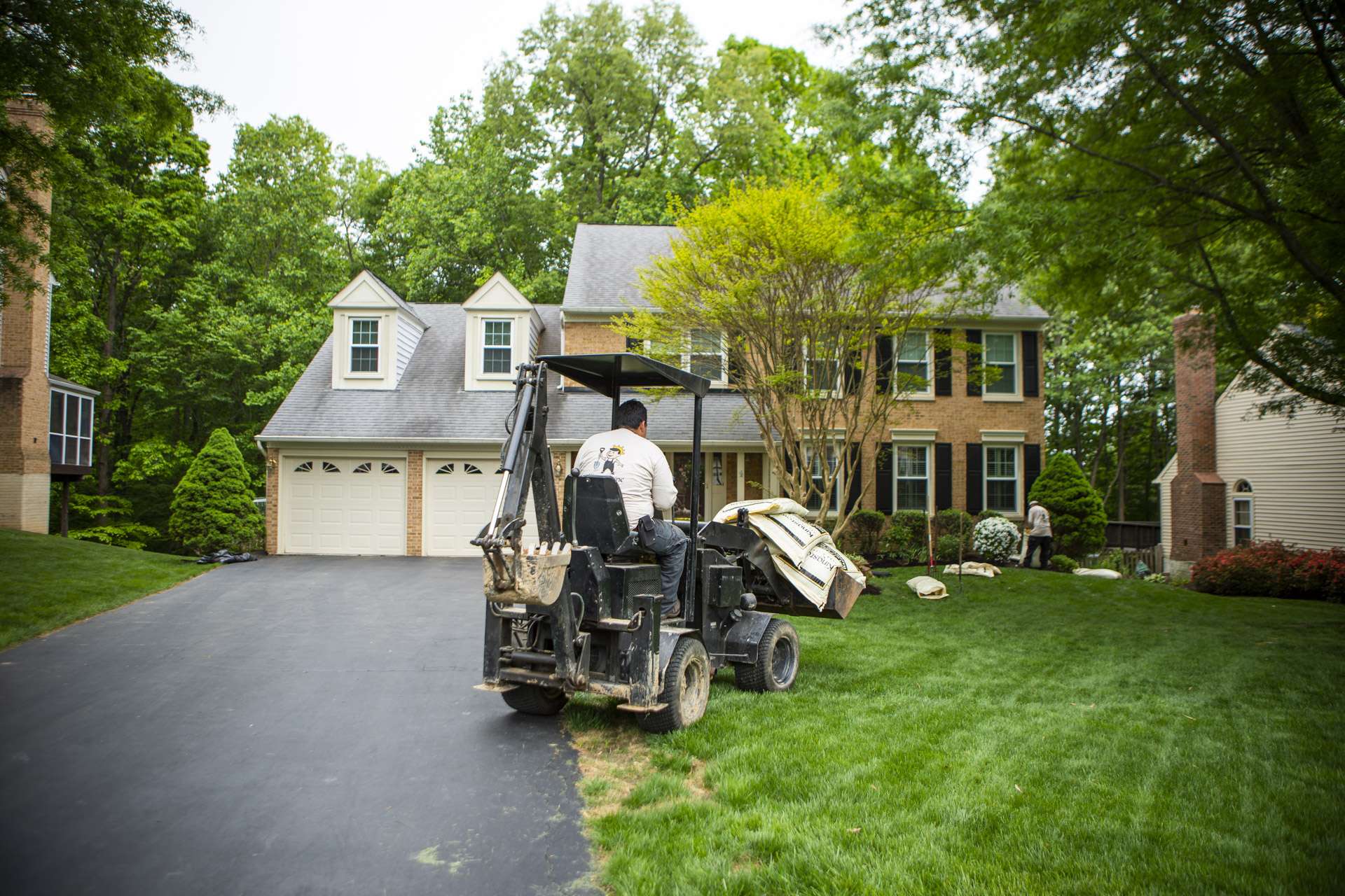 Landscape installation team driving a mini tractor