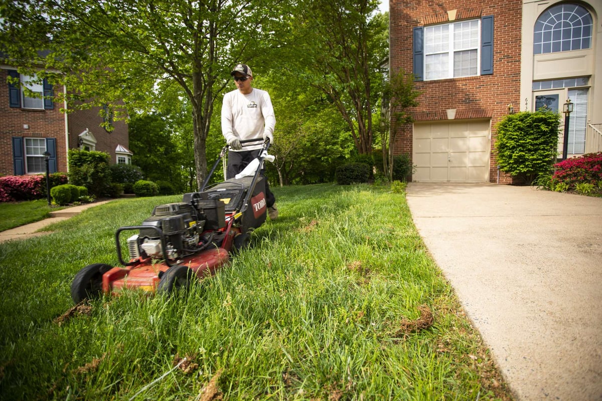 landscape maintenance team mows lawn