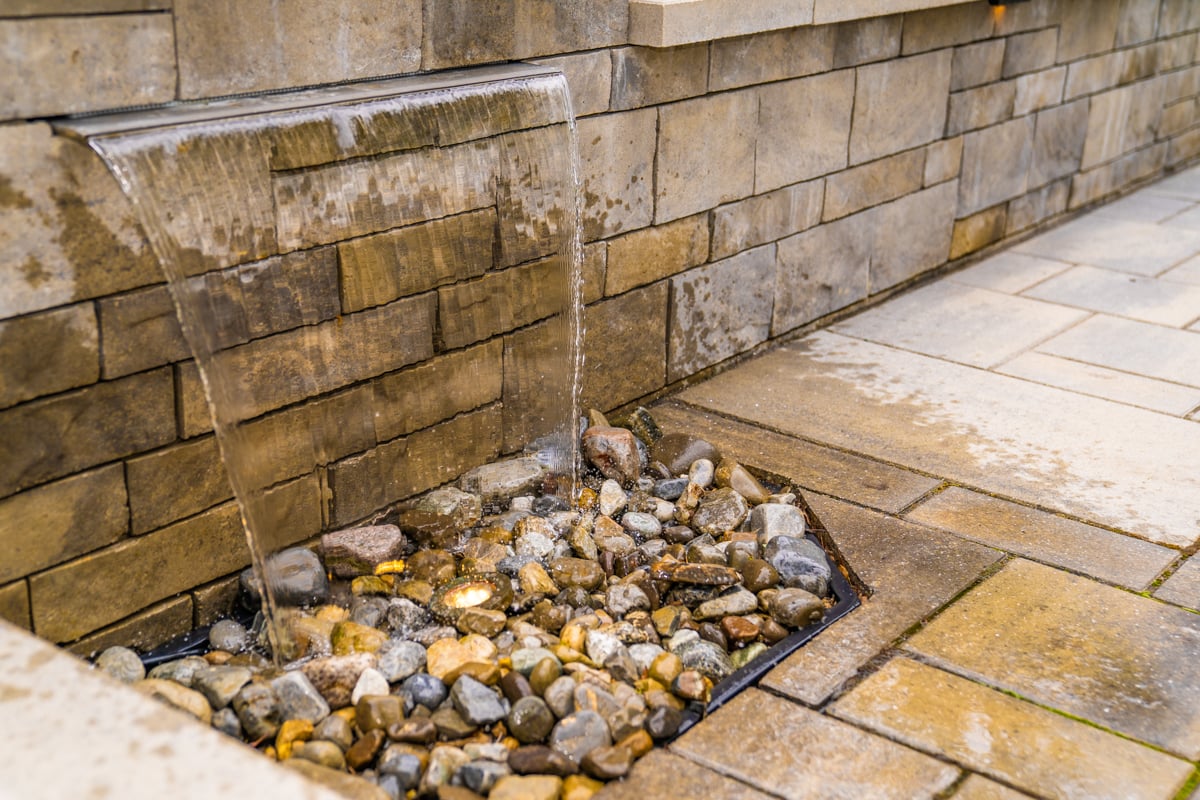 pondless waterfall feature with hardscape patio and retaining wall