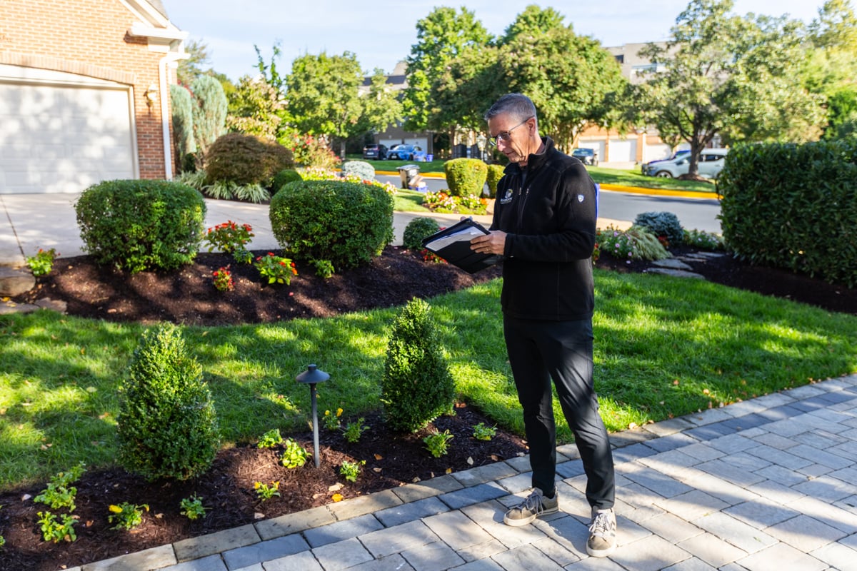 account manager landscape designer inspecting property