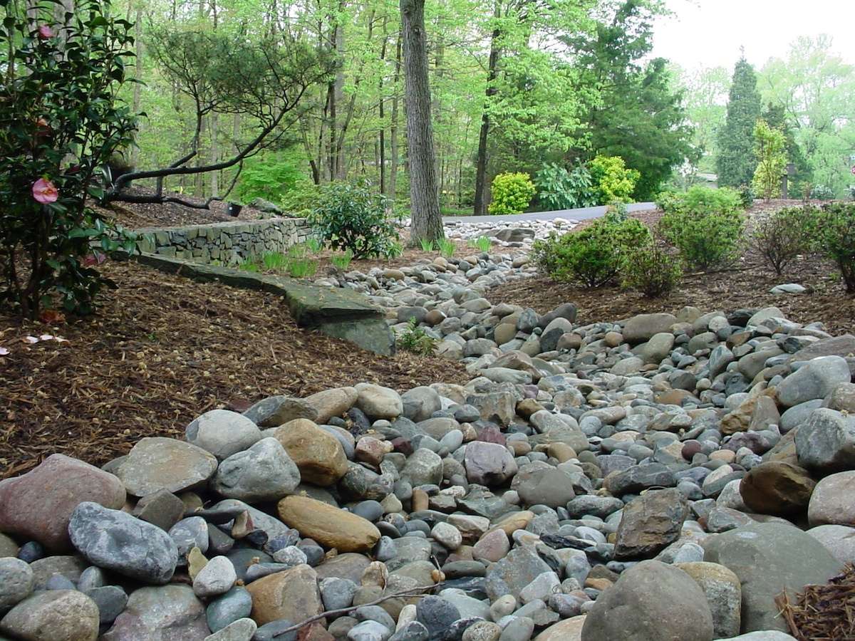 dry creek bed for lawn drainage with river rock and grading