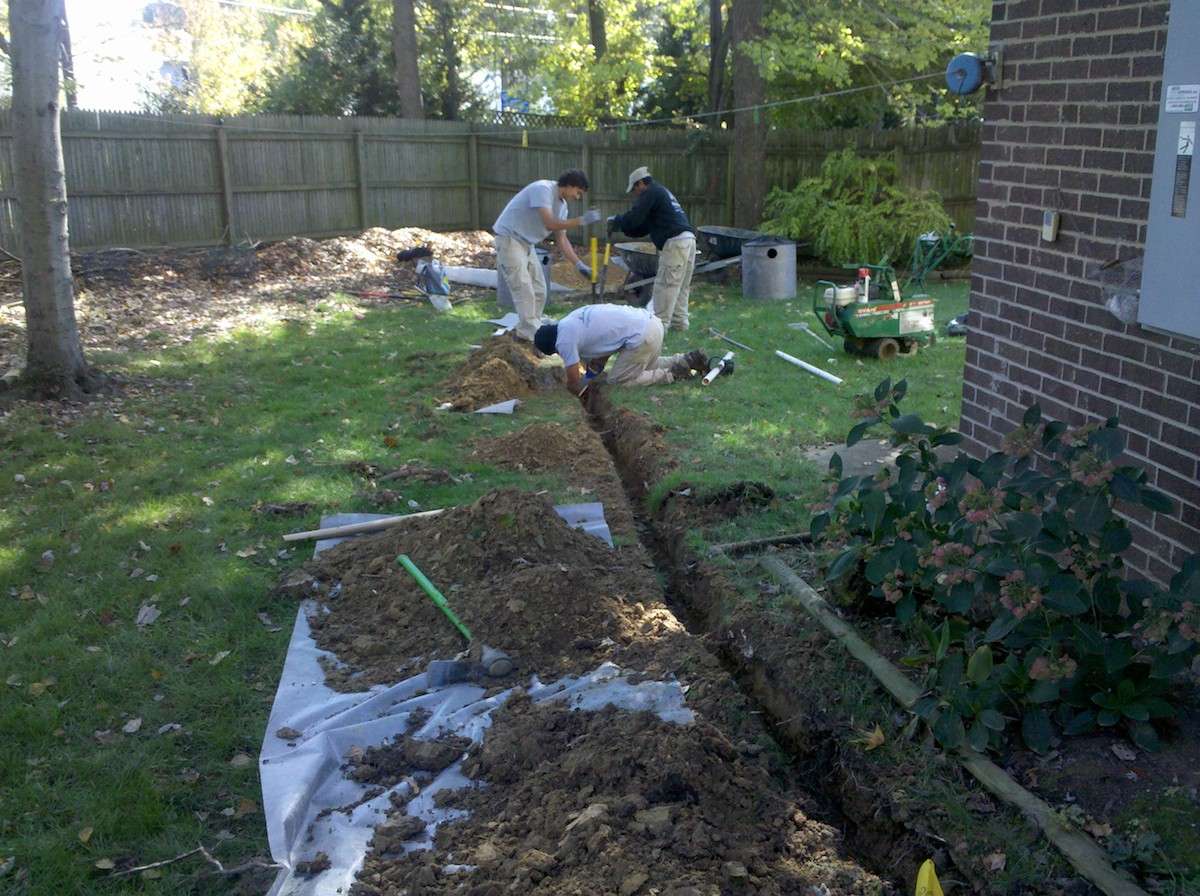 Landscapers working on drainage trench 