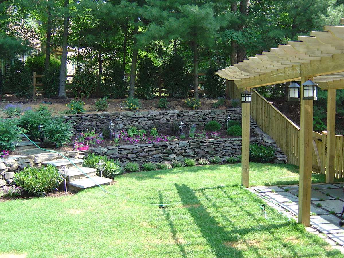 sloped backyard with retaining walls and plants
