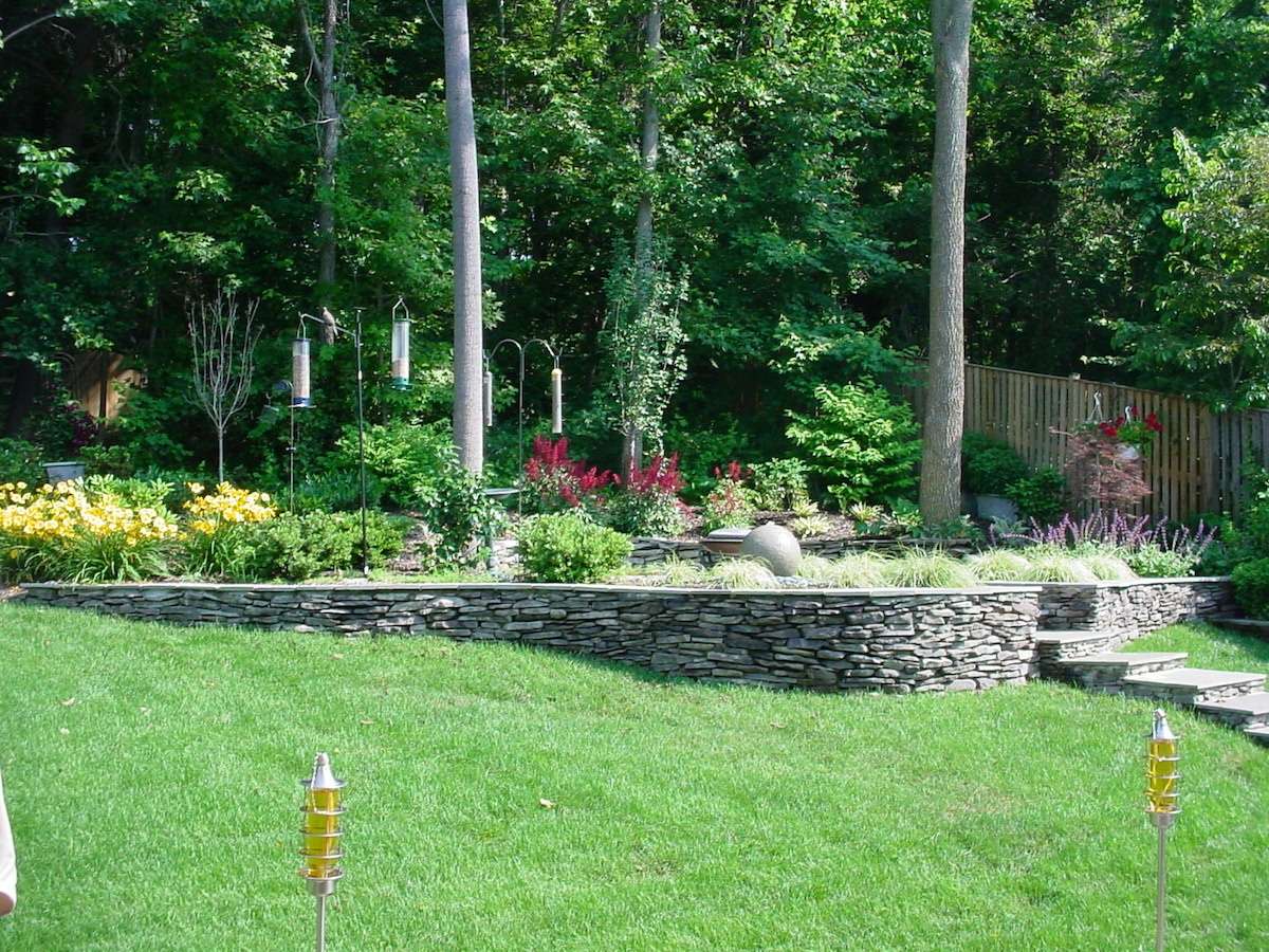 sloped yard with retaining wall stacked stone 