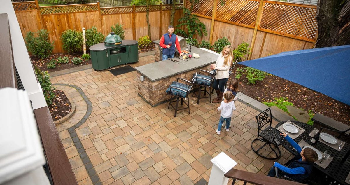 family outside on paver patio in small backyard