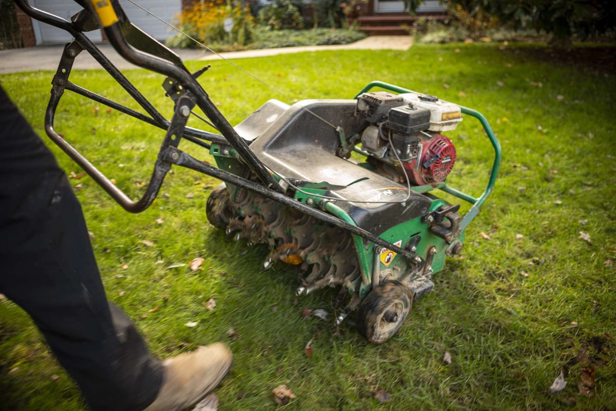 lawn care technician aerates lawn before seeding