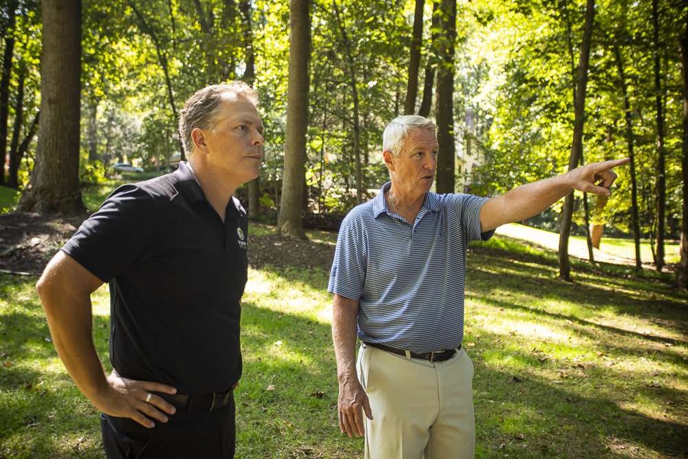 pest control expert and homeowner inspect property