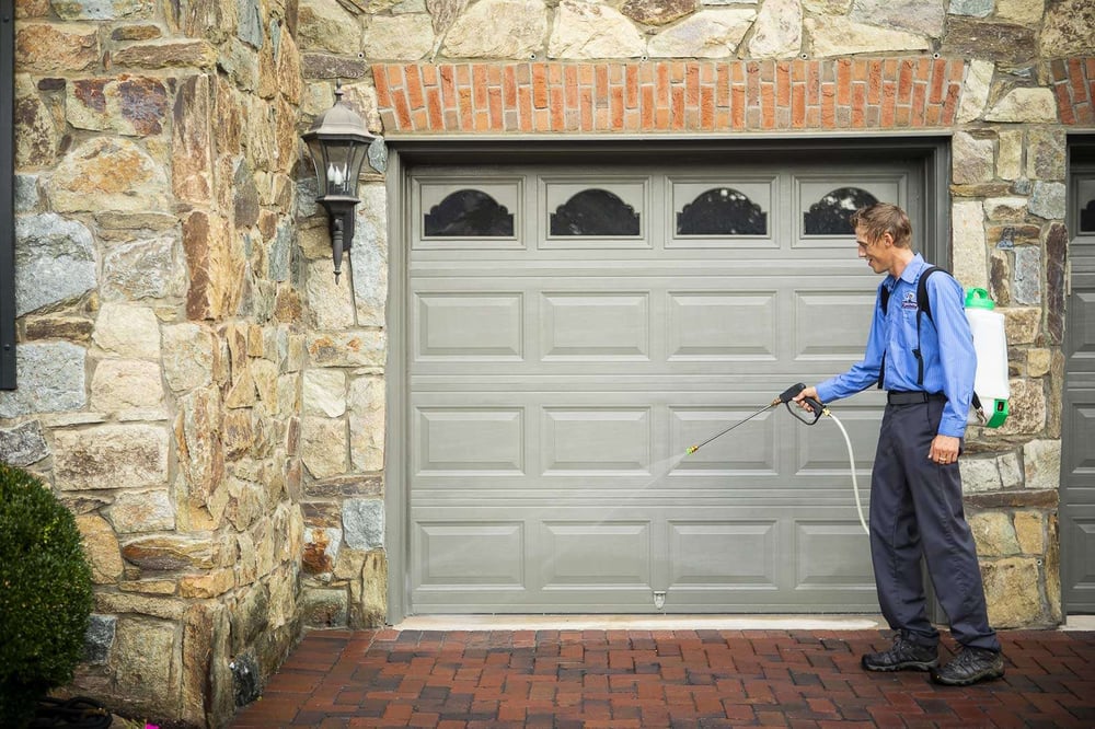 pest control technician spraying outside