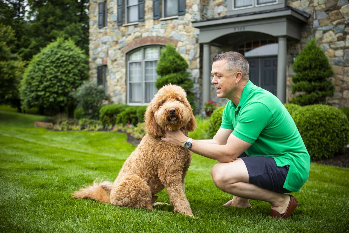 man with dog on lawn