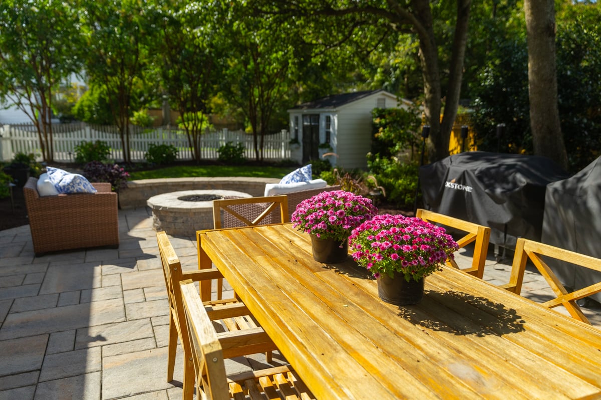 nice patio furniture fire pit and sitting wall with shade trees