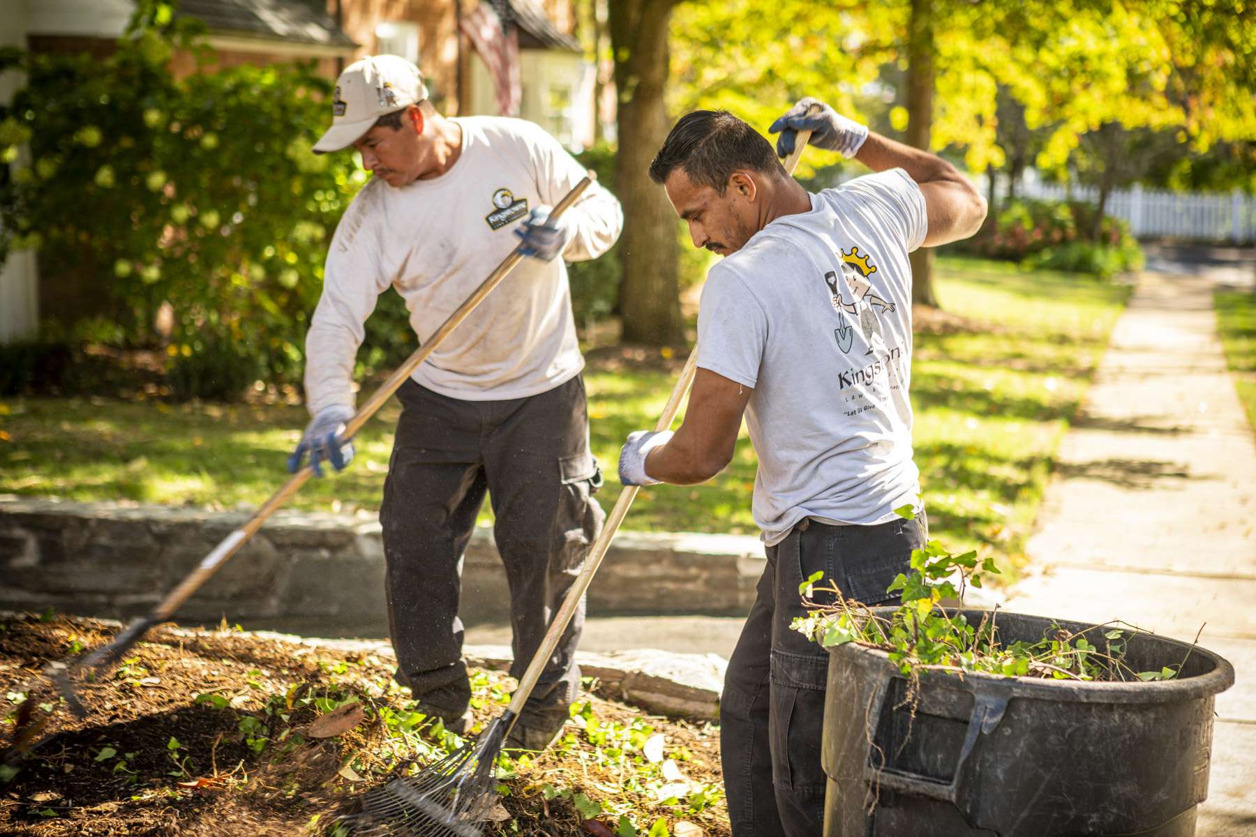 landscape maintenance team rake leaves out of landscape bed