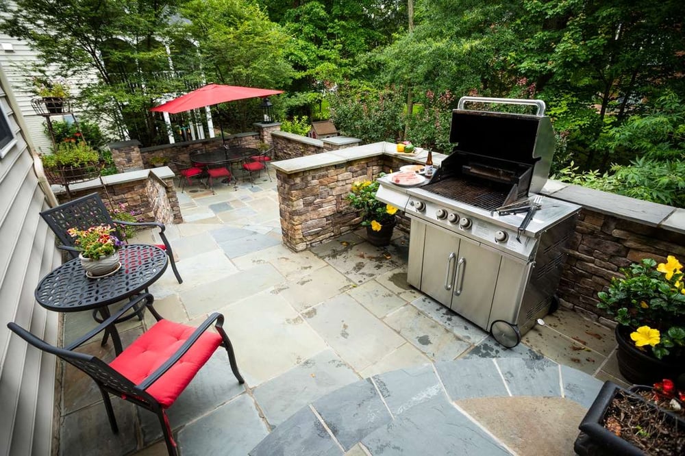 patio, grill, and dining area designed by Kingstowne Lawn & Landscape