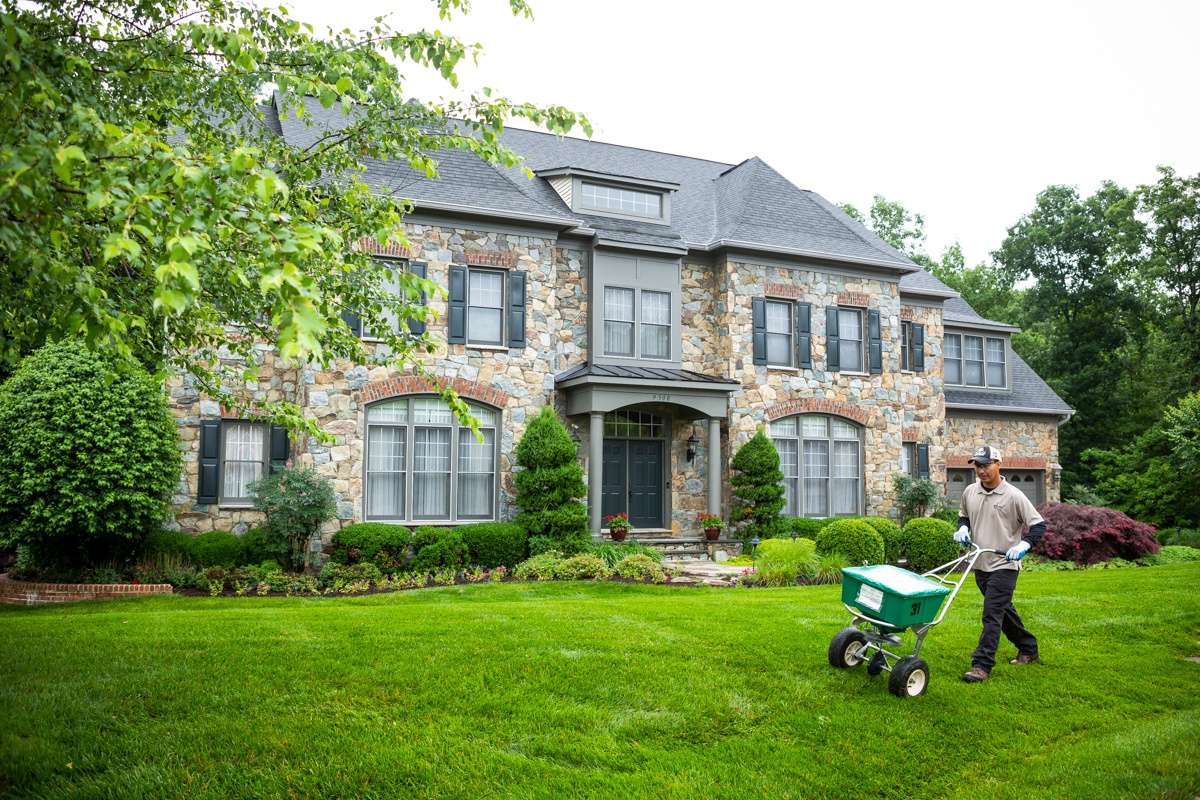 lawn care technician applying limestone treatment