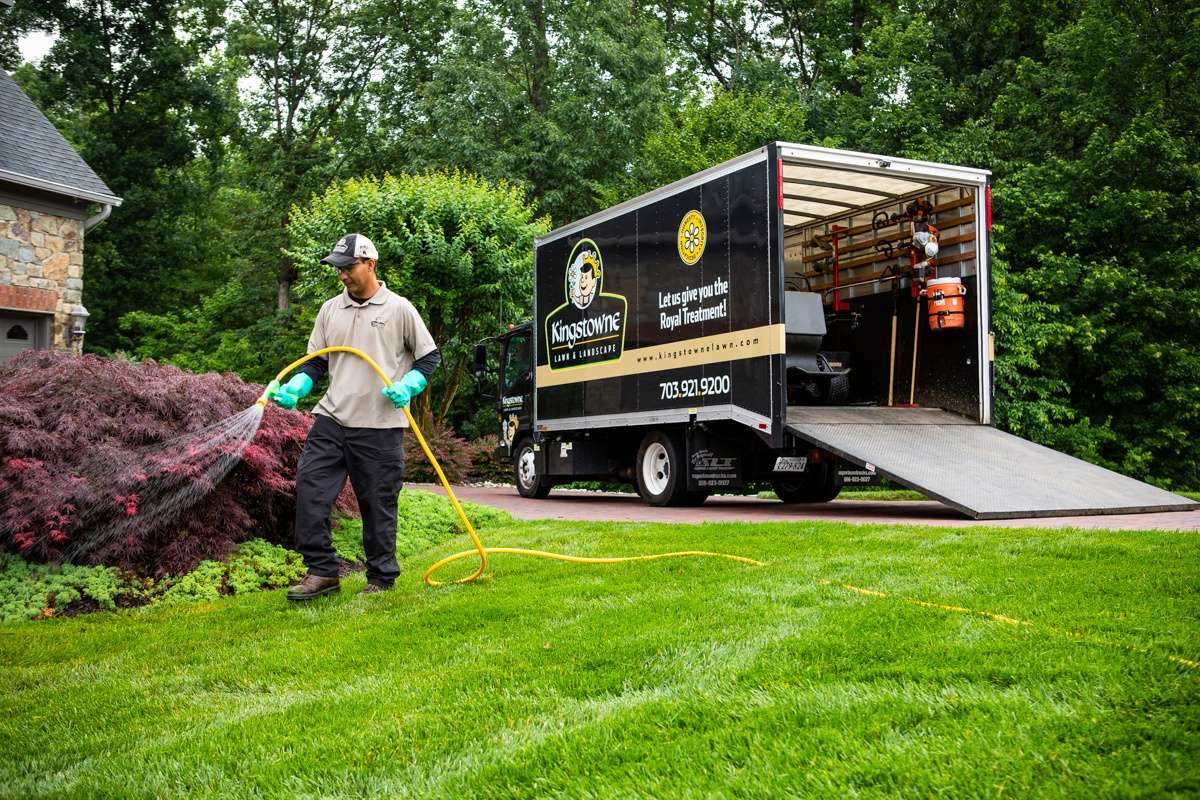 lawn care services technician spraying lawn