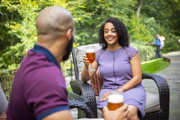 couple sits on patio while pest control team sprays for mosquitoes