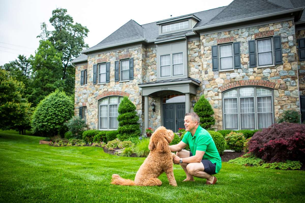 homeowner plays with dog outside