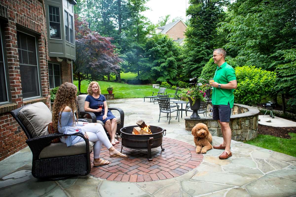 free-standing fire pit on patio with family and dog