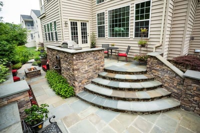 Patio with steps, wall, fountain, and grill
