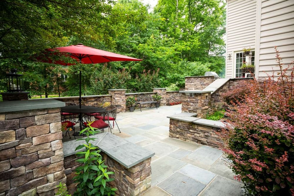 patio with retaining walls, dining area, plants and fountain